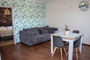 a living room with a couch and a table with chairs at Azyl in Dębki