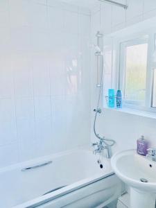 a white bathroom with a shower and a sink at Wonderful Apartment in London in The Hyde