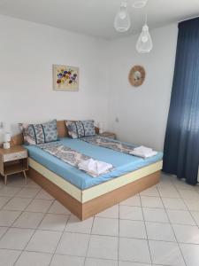 a bed in a room with a blue curtain at Къща за гости СТЕЛА in Primorsko