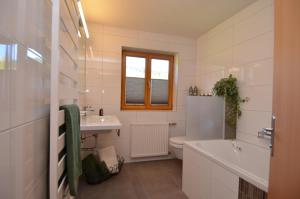 a white bathroom with a sink and a toilet at Pension Mallaun in Lech am Arlberg