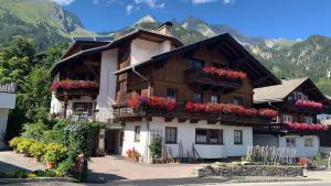 un bâtiment avec des fleurs sur ses balcons dans l'établissement Blusnerhof, à Virgen