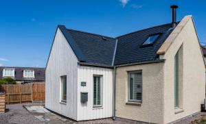 a small white house with a black roof at Lily Cottage - Brand new 1 bedroom in Forres