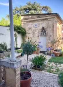 un viejo edificio de ladrillo con plantas en un patio en Gogascony en Lavit