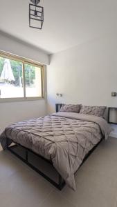 uma cama grande num quarto branco com uma janela em 3 pièces dans villa avec piscine em Nice