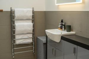 ein Badezimmer mit einem weißen Waschbecken und Handtüchern in der Unterkunft Lily Cottage - 1 bedroom in Forres