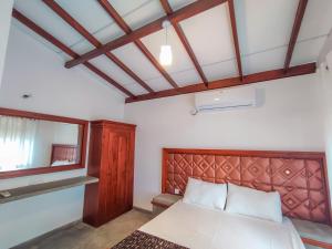 Schlafzimmer mit einem Bett und einem Spiegel in der Unterkunft Peacock Village Pinnawala in Pinnawala