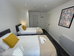 two beds in a small room with yellow and white at Southbank Stays Premium Apartment - Sleeps 4 in Coventry