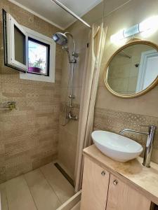 a bathroom with a sink and a shower with a mirror at ilianas place in Ágios Matthaíos