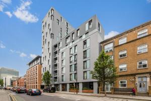 a tall white building on a city street with cars at 1 Bedroom Close to Tower Hill in London