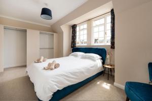 a bedroom with a large bed with teddy bears on it at Tranquil 3BD Haven by the Sea in Littlehampton in Littlehampton