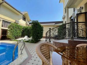 un patio con mesa y sillas junto a una piscina en Alliance Hotel Tashkent, en Tashkent