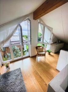 a living room with large windows and a chair at Ferienwohnung mit Charme in Eurasburg