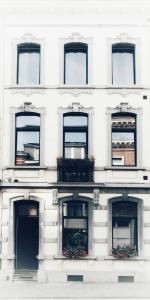 un edificio blanco con ventanas y cajas de flores. en La Maison de Chestret en Lieja