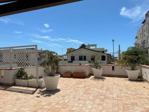 eine Terrasse mit Topfpflanzen auf dem Dach in der Unterkunft Villa San Leo in San Leone