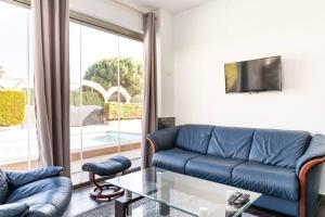 a living room with a blue couch and a glass table at Villa Constantinos apartamentos o villa completa in Calpe