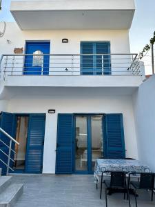 ein Haus mit blauen Fensterläden und einem Balkon in der Unterkunft Kato Zaros Apartments in Zarós