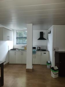 een keuken met witte kasten en een paal in een kamer bij Unit 5 in Aizawl