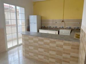 uma cozinha com um balcão e um frigorífico em BOUS Appartement Tichy 2 em Tichi