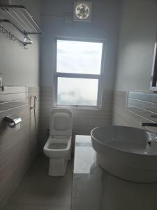 een badkamer met een bad, een toilet en een raam bij Unit 5 in Aizawl
