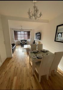 a dining room with a table and chairs and a living room at The Peaceful Place in Cheshunt