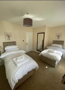 a bedroom with two beds and a mirror at The Peaceful Place in Cheshunt