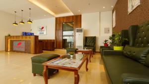 vestíbulo con sofá, mesa y sillas en Magnus Square Business Hotel en Pune