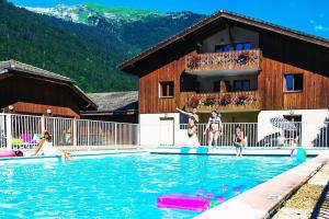 a group of people playing in a swimming pool at Bel appartement avec piscine - Le Grand Tétras in Samoëns