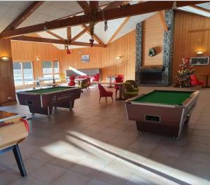 a large room with billiard tables and chairs in it at Bel appartement avec piscine - Le Grand Tétras in Samoëns