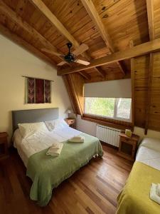 a bedroom with two beds and a ceiling at Buena Vida Social Club in El Bolsón