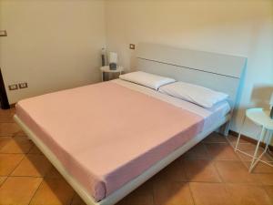 um quarto com uma cama grande e lençóis cor-de-rosa em Casa Degli Ulivi em Lazise