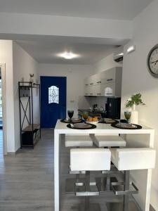 a kitchen with a white island with two stools at Kato Zaros Apartments in Zarós