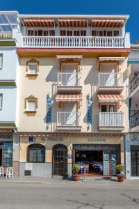 an apartment building with balconies on a street at Hostal El Puerto in Caleta De Velez