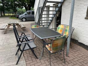 een tafel en stoelen naast een trap bij Familiehuis voor 13 personen in Diever