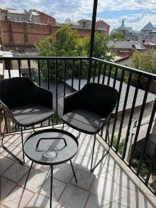 two chairs and a table on a balcony at Sumskaya Apartment Lux in Kharkiv