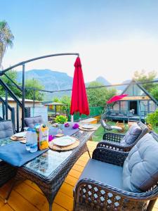 a table with chairs and an umbrella on a deck at TERRACE BUNGALOW in Kemer