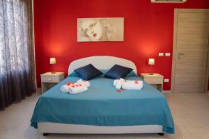 - une chambre avec un lit bleu et des serviettes dans l'établissement Il Tramonto B&B, à Castelluzzo