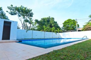een zwembad naast een wit hek bij Thinaya lake resort in Anuradhapura