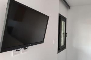 a flat screen tv hanging on a wall with a mirror at Leptokarya Rooms Wooden Luxury in Leptokarya