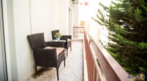 een balkon met rieten stoelen en een kerstboom bij Explore Greece from City Centre Apartment in Chalkida
