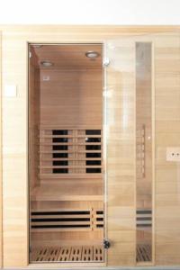 una puerta de cristal de un armario en una habitación en Maison avec piscine, sauna pour 8/10 personnes, en Romainville