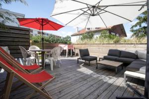 un patio con mesa, sillas y sombrilla en Maison avec piscine, sauna pour 8/10 personnes, en Romainville