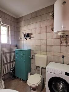 a bathroom with a toilet and a washing machine at Nature Guest House Sarajevo in Sarajevo