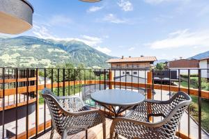 eine Terrasse mit einem Tisch und Stühlen auf dem Balkon in der Unterkunft Zillertal Suites Fügen by ALPS RESORTS in Fügen