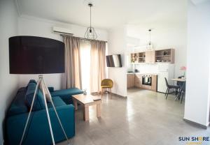sala de estar con sofá azul y cocina en Explore Greece from City Centre Apartment, en Chalkida