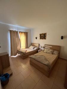 1 dormitorio con 2 camas y ventana en Palmera Chalets Owners Best Vacation Group Families only, en Ain Sokhna