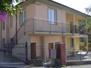 ein Haus mit einem Balkon an der Seite in der Unterkunft Wayne's house, a short walk to the waterfalls in Bagnone