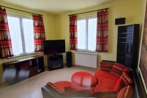 a living room with a red chair and a tv at Wayne's house, a short walk to the waterfalls in Bagnone