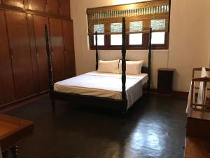 - une chambre avec un lit à baldaquin et une fenêtre dans l'établissement Dunwatta House, à Kandy
