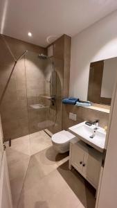 een badkamer met een douche, een toilet en een wastafel bij Villa Melanie in Überlingen