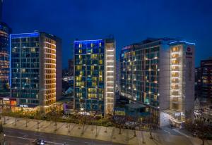 two tall buildings in a city at night at Best Western Premier Marina Las Condes in Santiago